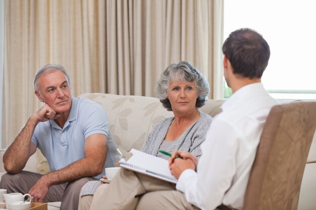 Couple sitting with an advisor taking notes, discussing the family impact of tremor and Parkinson's Disease.