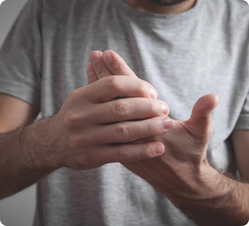 A close-up of a person's hands clasped together in front of a light gray t-shirt.