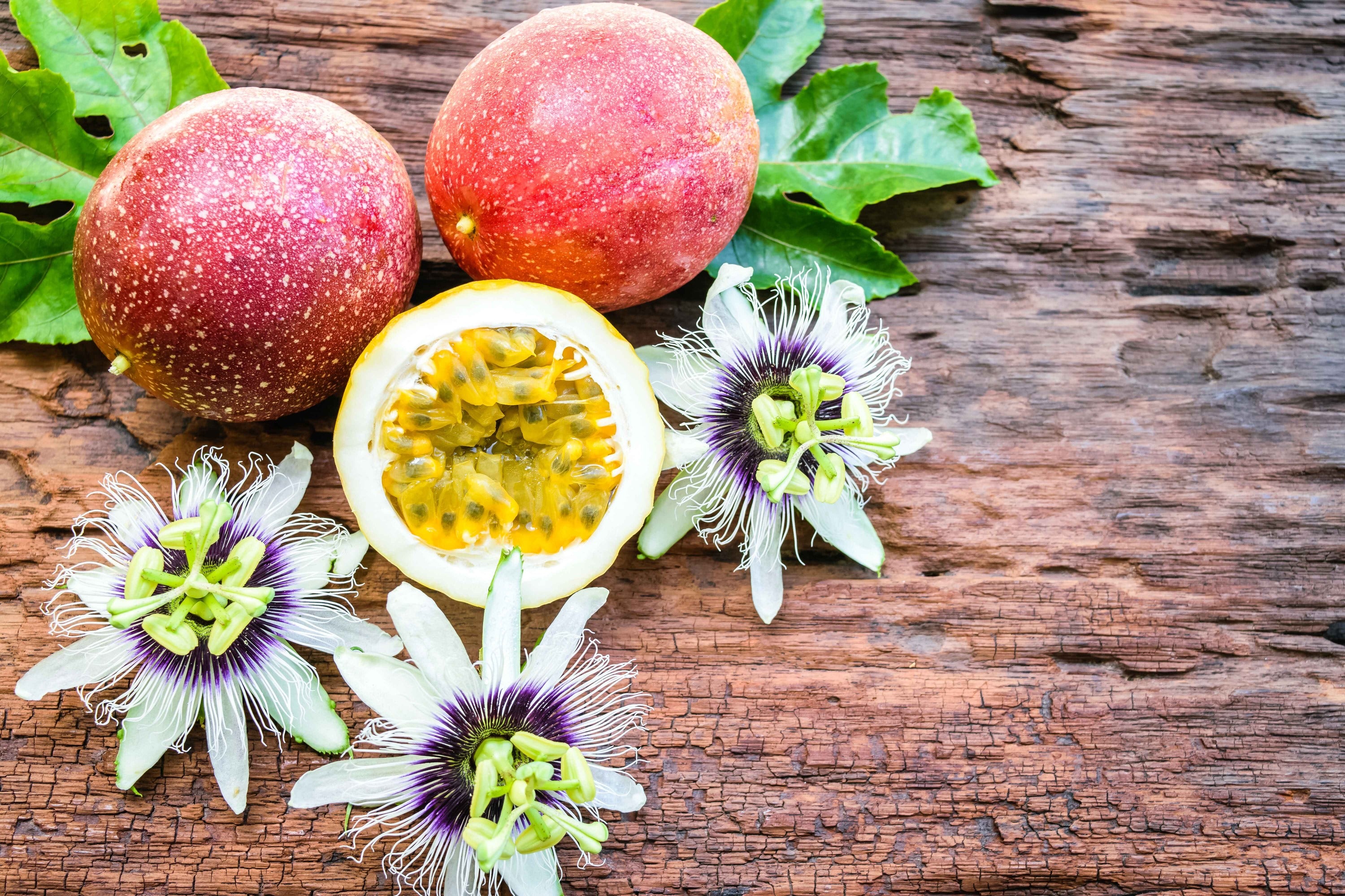  Passion fruit and flowers on a wooden surface.