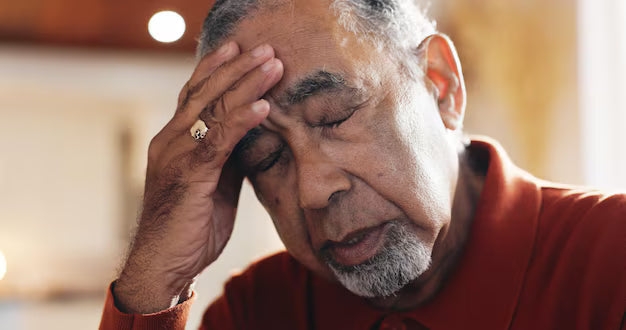 Man resting his head in his hand, expression showing Essential Tremor self-consciousness.