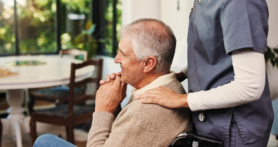 Caregiver helping an older man walk in the kitchen, an example of caring for someone with tremor.