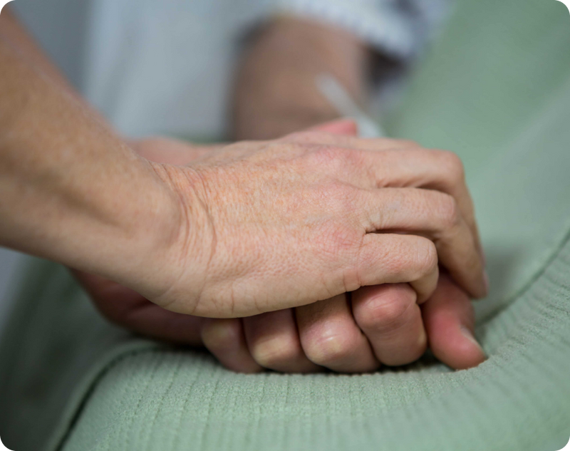 Best gifts for Parkinson's patients where a physiotherapist assists a male patient with an arm exercise band.
