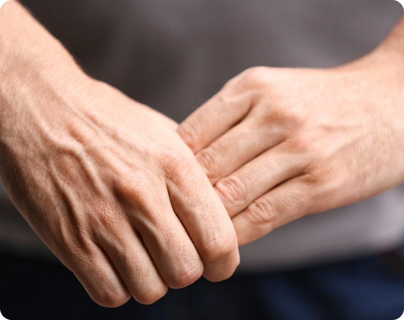 Essential Tremor surgery candidate, where a senior woman is holding her wrist in pain during a medical exam.