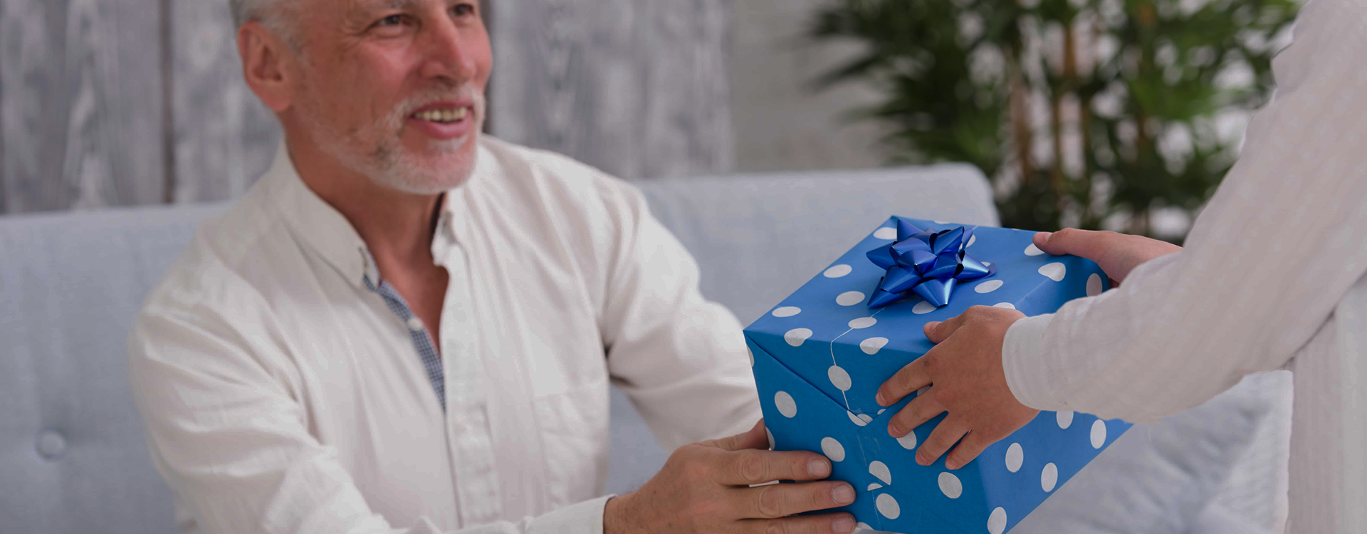Gifts for Parkinson's patients that a cheerful senior woman is receiving a gift box.
